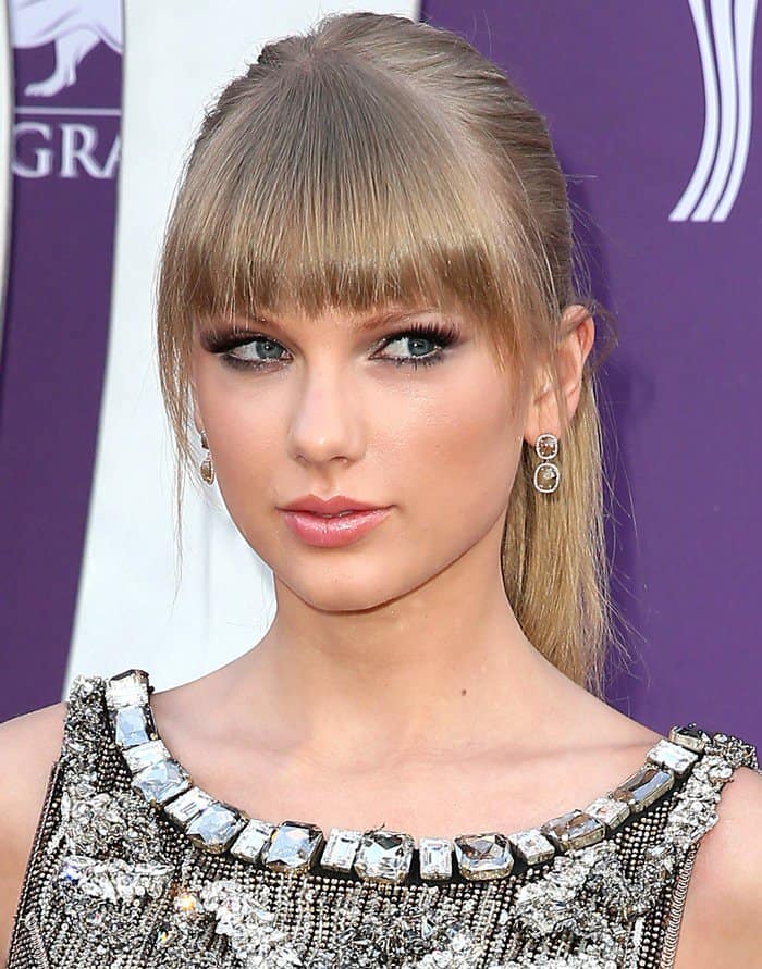 Showcasing her iconic fringe, Taylor Swift complements her Dolce & Gabanna gown with understated elegance at the ACM Awards