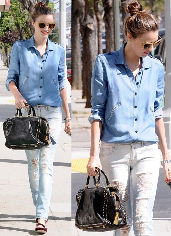 In Hollywood on April 8, 2013, Miranda Kerr sported a fashionable Prada black calfskin studded medium tote, complementing her casual chic outfit that included a Scanlan & Theodore denim shirt, Mango jeans with decorative rips, Miu Miu velvet smoking slippers, Miu Miu cat-eye sunglasses in yellow glitter, and a Rolex Oyster Perpetual Air-King watch
