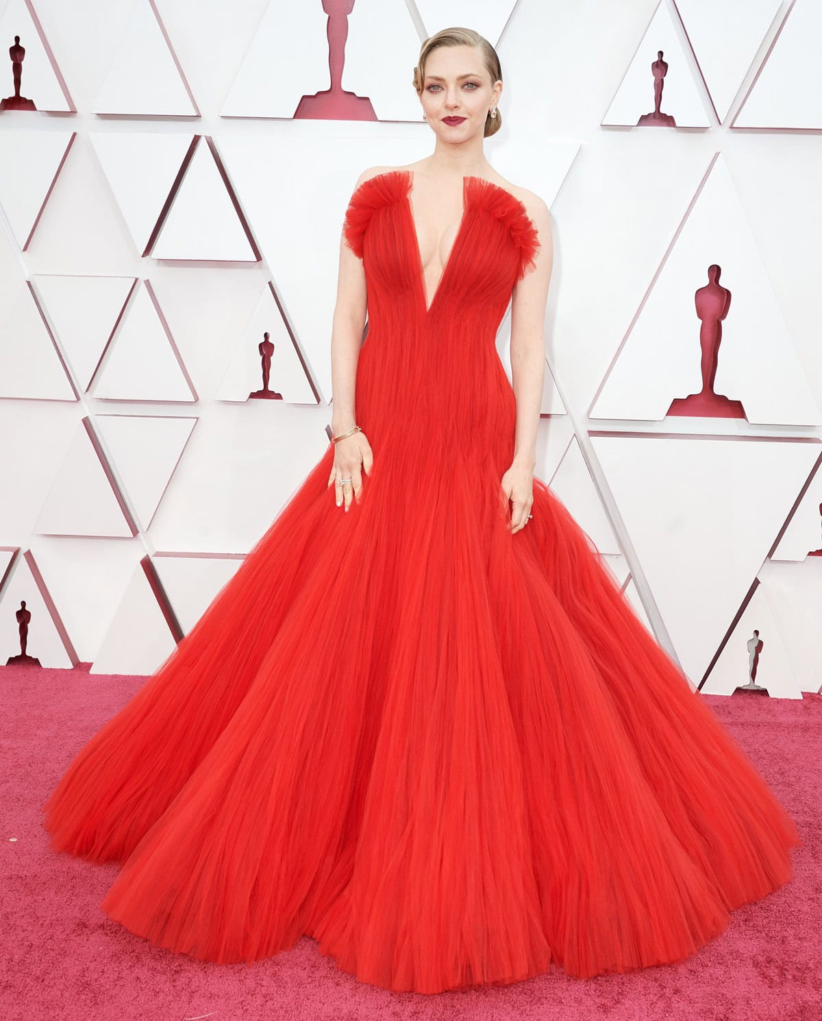 Amanda Seyfried channeled vintage Hollywood glamour at the 93rd Academy Awards in a custom scarlet tulle ball gown by Giorgio Armani Privé, completing the look with Stuart Weitzman heels, yellow diamond earrings, and a sleek retro updo that paid homage to her Mank character, Marion Davies