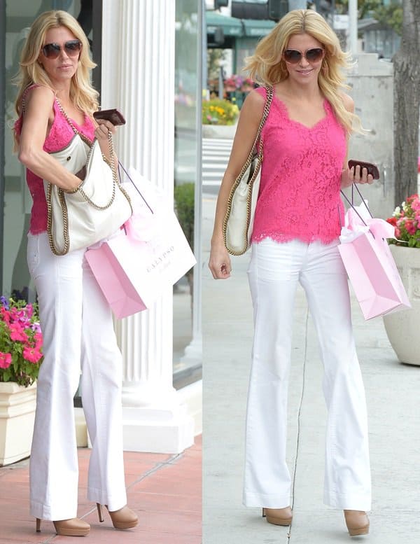 Brandi Glanville stylishly combines white bootcut jeans with a pink lace top and beige-heeled booties while shopping in LA