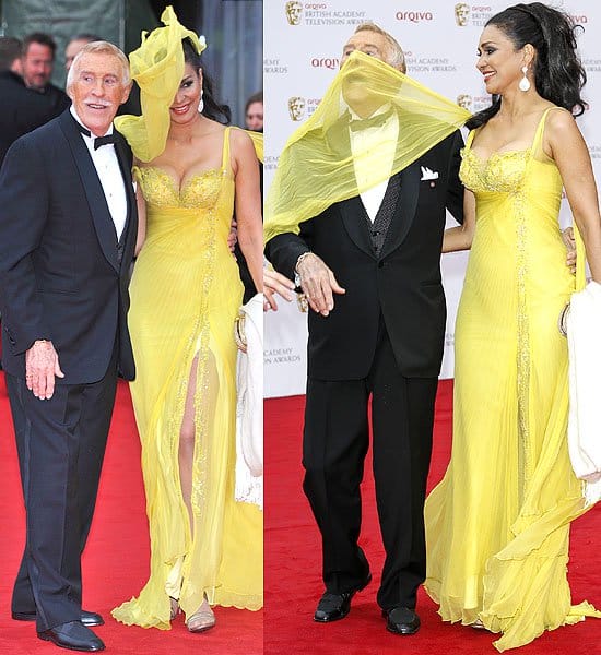 Wilnelia Merced Forsyth's scarf playfully envelops her husband, Bruce Forsyth, during a windy evening at the 2013 Arqiva British Academy Television Awards in London