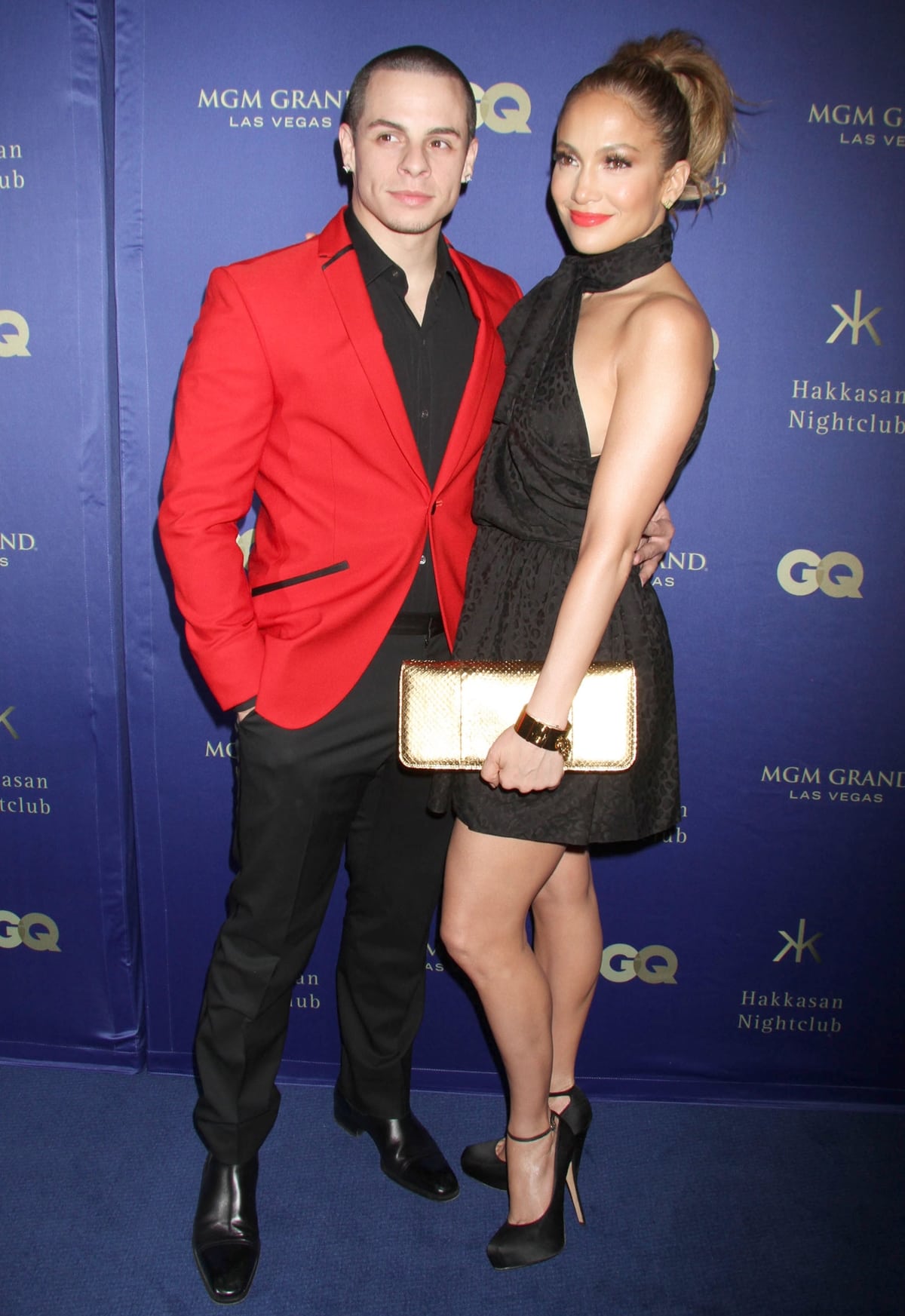 Jennifer Lopez stuns in a black Saint Laurent mini dress, Brian Atwood platform pumps, and gold accessories as she poses with boyfriend Casper Smart at the Hakkasan Las Vegas Grand Opening at the MGM Grand Hotel on April 27, 2013