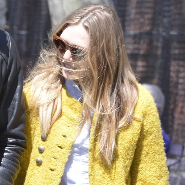 Elizabeth Olsen radiates in a yellow coat, pairing it elegantly with a white top during a sunny spring day in SoHo, New York City, April 30, 2013