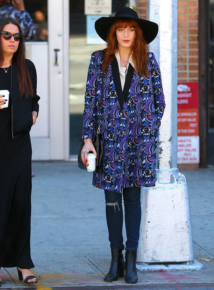 Florence Welch pairs a paisley-printed coat with classic jeans, complemented by a Miu Miu 'Vitello' handbag and a stylish floppy hat in NYC