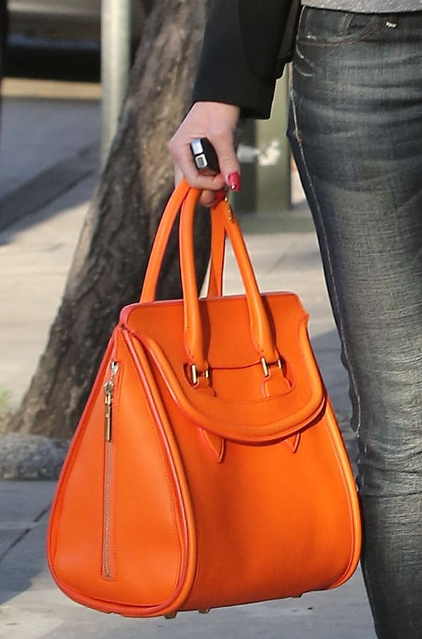 Gwen Stefani carries her orange Alexander McQueen bag