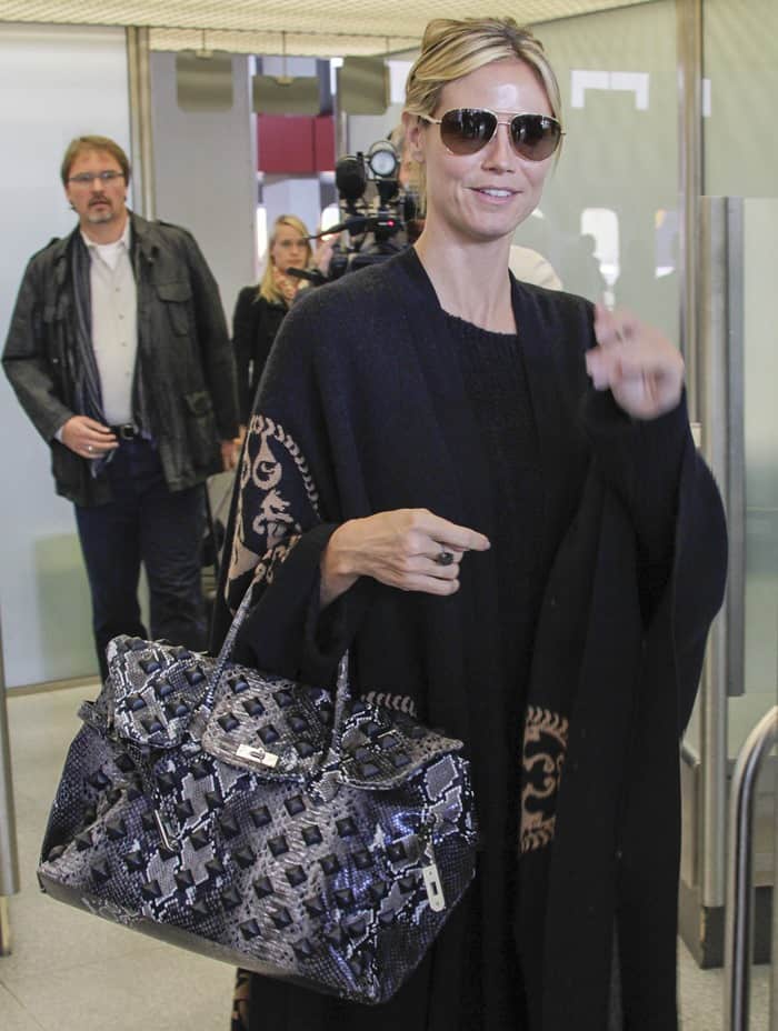 Supermodel Heidi Klum elegantly arrives with her Hermes 'Birkin' snakeskin bag at Berlin's Tegel Airport, dressed in a stylish all-black outfit, ready to tackle the chilly German weather on May 27, 2013