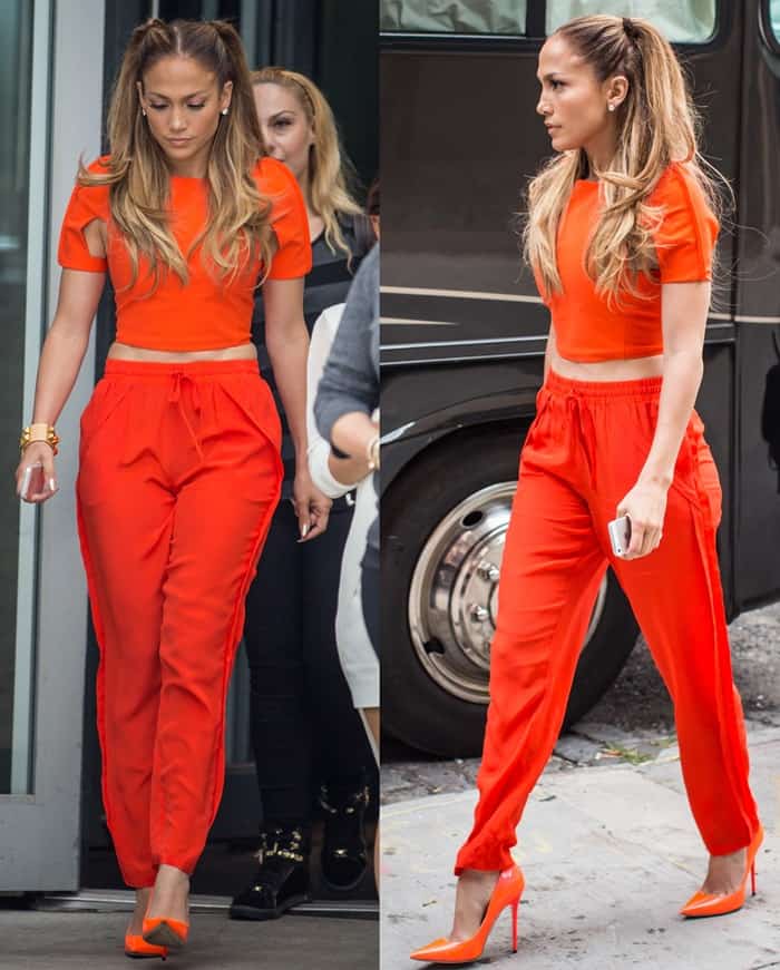Jennifer Lopez dazzles in head-to-toe orange, demonstrating a bold and stylish outfit choice during a music video shoot