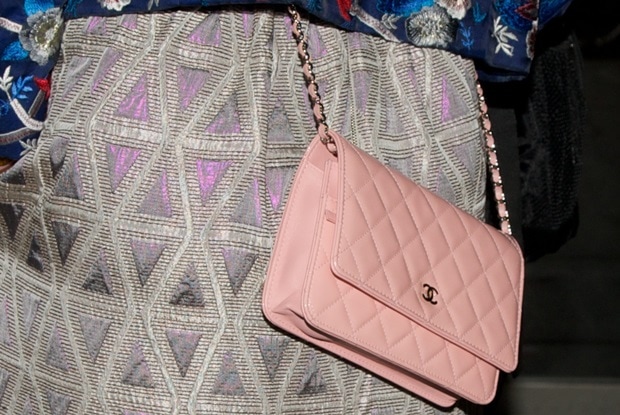 Katy Perry elegantly displays her classic pink Chanel handbag, adding a touch of luxury to her floral ensemble