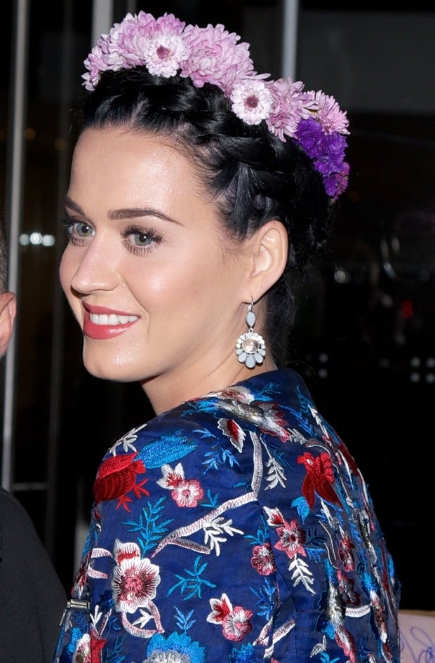 Katy Perry demonstrates a captivating look combining braided hair with a floral headpiece, enhancing her ethereal outfit