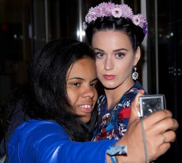 Katy Perry shares a joyful moment with a fan, capturing the warm interaction with her enchanting floral attire