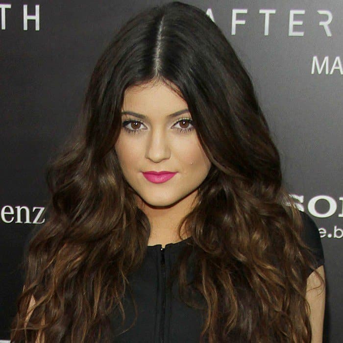 Radiant Waves: Featuring voluminous, cascading brunette curls and a pop of bold pink lipstick, Kylie Jenner brings a touch of glamour to the red carpet event