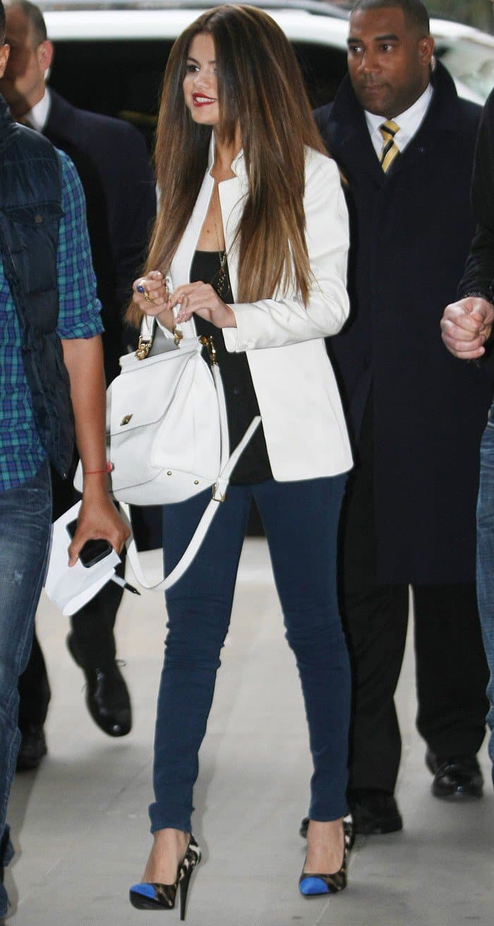 Selena Gomez shows how to elevate a chic casual look by pairing teal skinny jeans with a structured white blazer, leopard cap-toe pumps, and a classic white Dolce & Gabbana bag