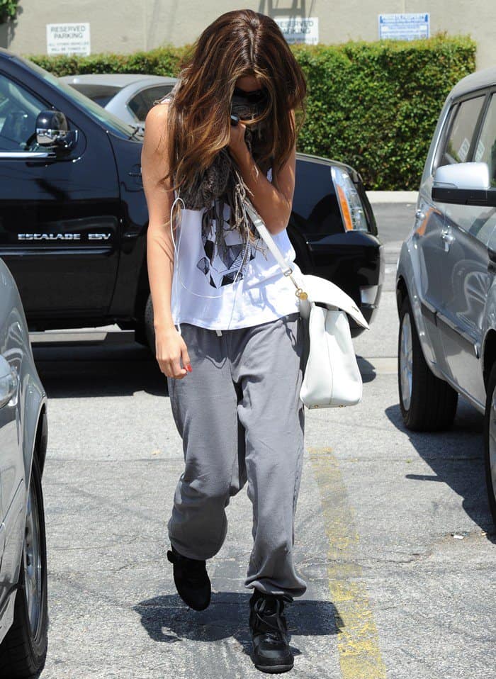 Selena Gomez was seen in Los Angeles wearing a Stylestalker Geo Bunny tee, paired with Top Moda Sammy 6 Velcro high top sneakers, accessorized with a Dolce & Gabbana Miss Sicily bag in Bianco, and wrapped in a BDG Cooperative two-way scarf