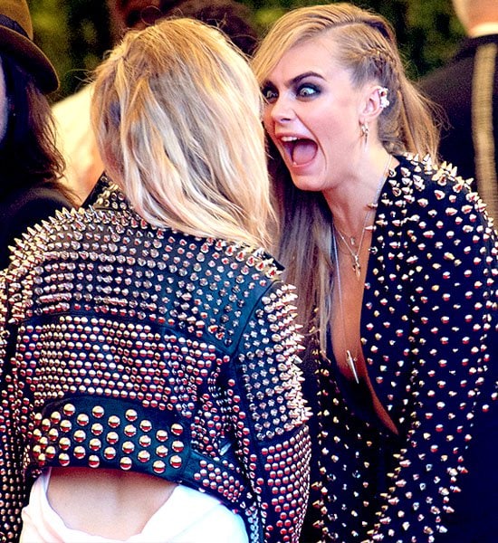 Cara Delevingne embodies the punk spirit in a spiked Burberry ensemble at the Met Gala 2013, sharing a playful moment with Sienna Miller