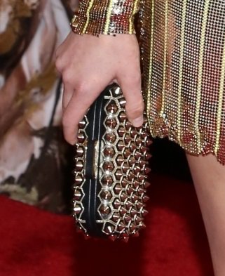 Elizabeth Banks paired her ultra-glamorous gold tuxedo jacket, worn as a dress, with a perfectly matched studded clutch at the Met Gala