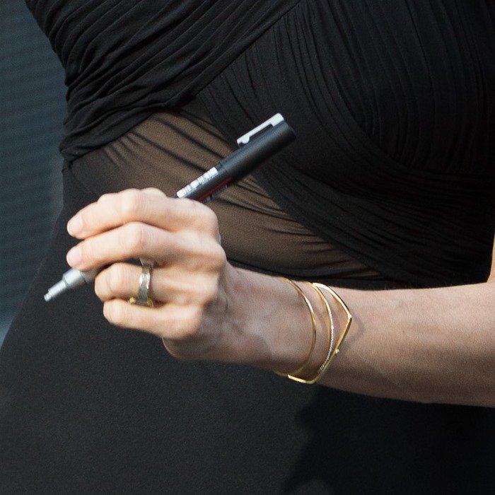 Angelina Jolie accessorized with two gold bracelets on each wrist
