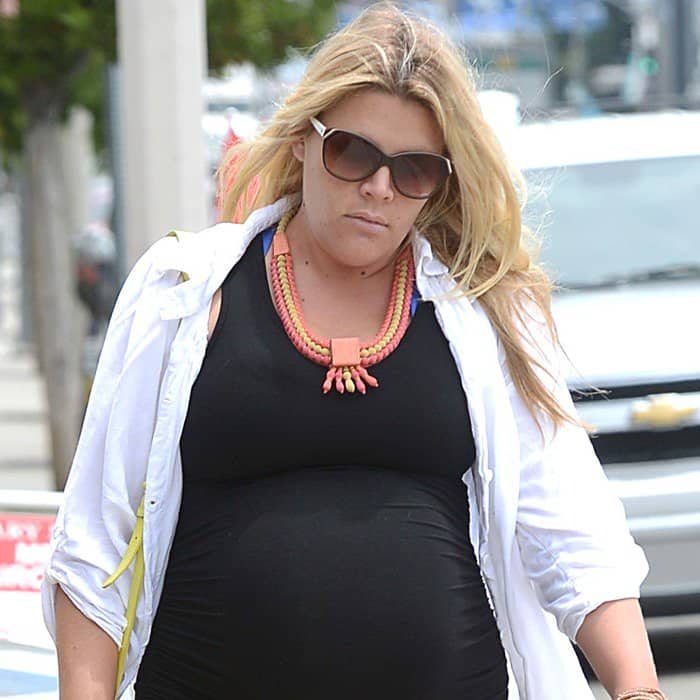 Busy Philipps elevates her chic black maternity dress with a vibrant orange beaded necklace, possibly designed by Irene Neuwirth
