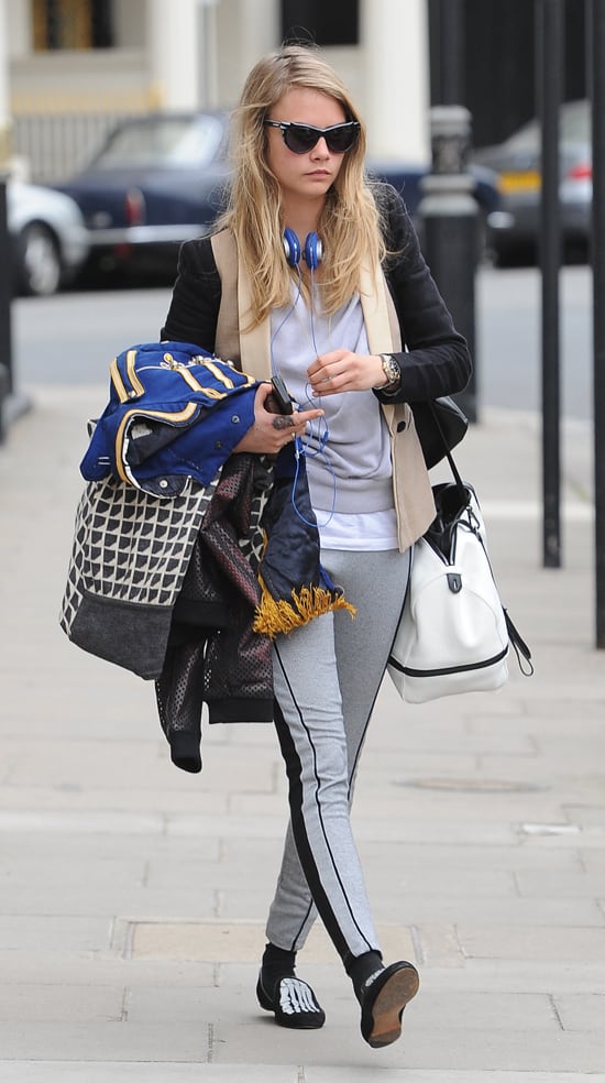 On June 12, 2013, in London, Cara Delevingne was seen wearing Topshop pipe panel leggings, Mara and Mine Jem Skull slippers, and Lulu Guinness batwing sunglasses