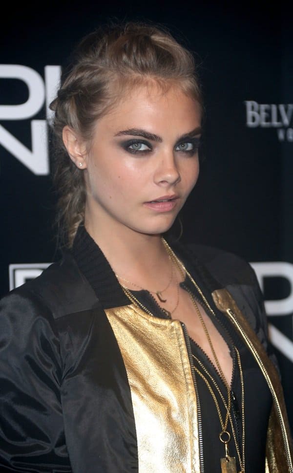 Cara Delevingne exudes casual elegance in a black varsity jacket with chic gold accents