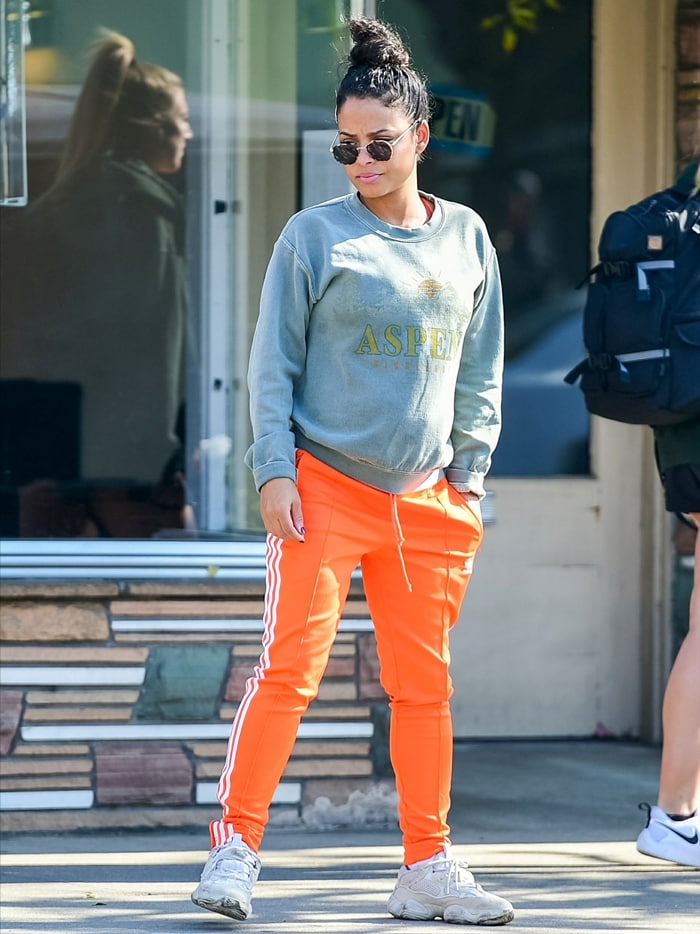 Christina Milian, an American actress/singer/songwriter of Cuban origin, dressed casually wearing a sweatshirt and orange pants