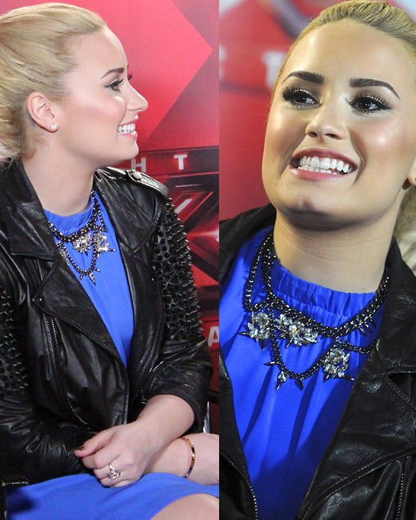 During The X Factor Judges Press Conference, Demi Lovato wore a blue Christopher Kane dress paired with a Philip Lim jacket and a Fallon necklace