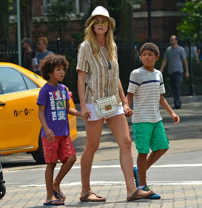 On June 24, 2013, in New York City, Heidi Klum was seen wearing Birkenstock Gizeh Birkibuc sandals, a Michael Michael Kors Sloan Stud Small shoulder bag, and an Equipment Riley Silk Python-Print top