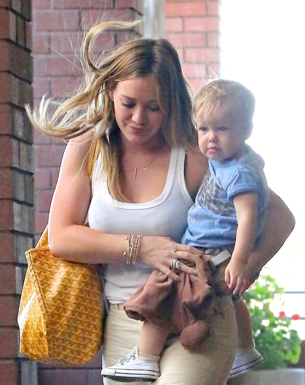 Hilary Duff enjoys a sunny day out in Brentwood with her son, Luca, wearing a simple white tank top and breezy linen pants, complemented by a Goyard handbag