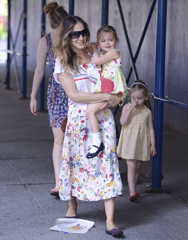 Captured in New York City, Sarah Jessica Parker enjoys a sunny day school run with her twin daughters, dressed in a vibrant print-on-print ensemble, May 30, 2013