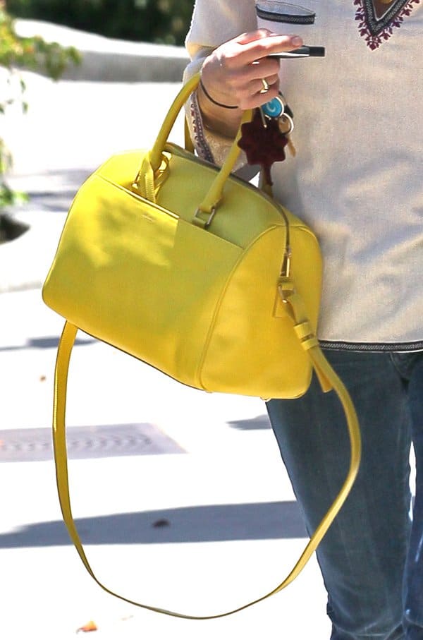 A close-up of Selma Blair's chic yellow Saint Laurent crossbody duffle bag