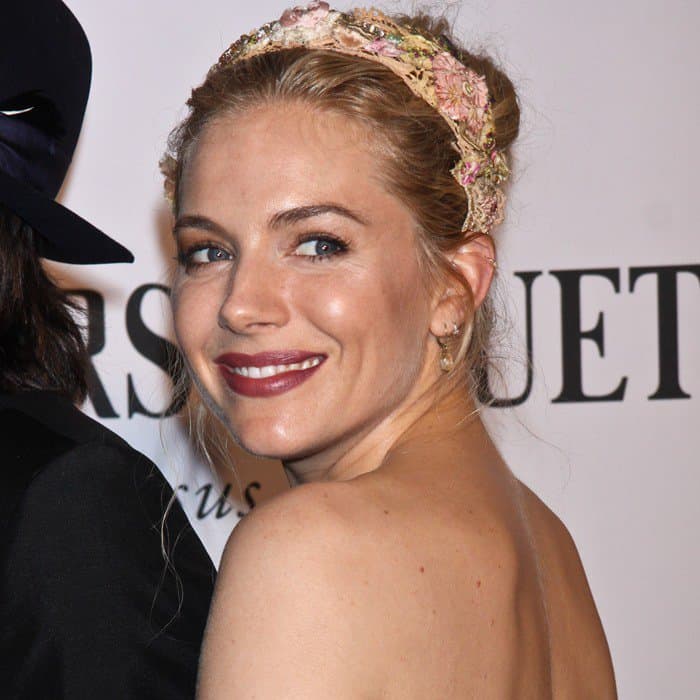 Sienna Miller enchants with a radiant smile, wearing a delicate floral headband at the 2013 Tony Awards