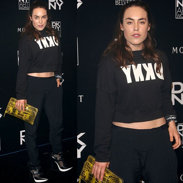 Tallulah Harlech rocking the DKNY "Pulse" booties with a DKNY sweatshirt, black track pants, and a croc-embossed clutch