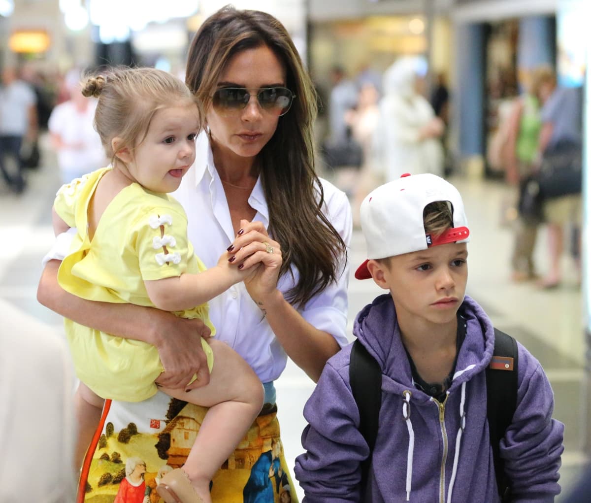 Victoria Beckham shows off her bronzed complexion with her daughter Harper Beckham and her son Romeo Beckham