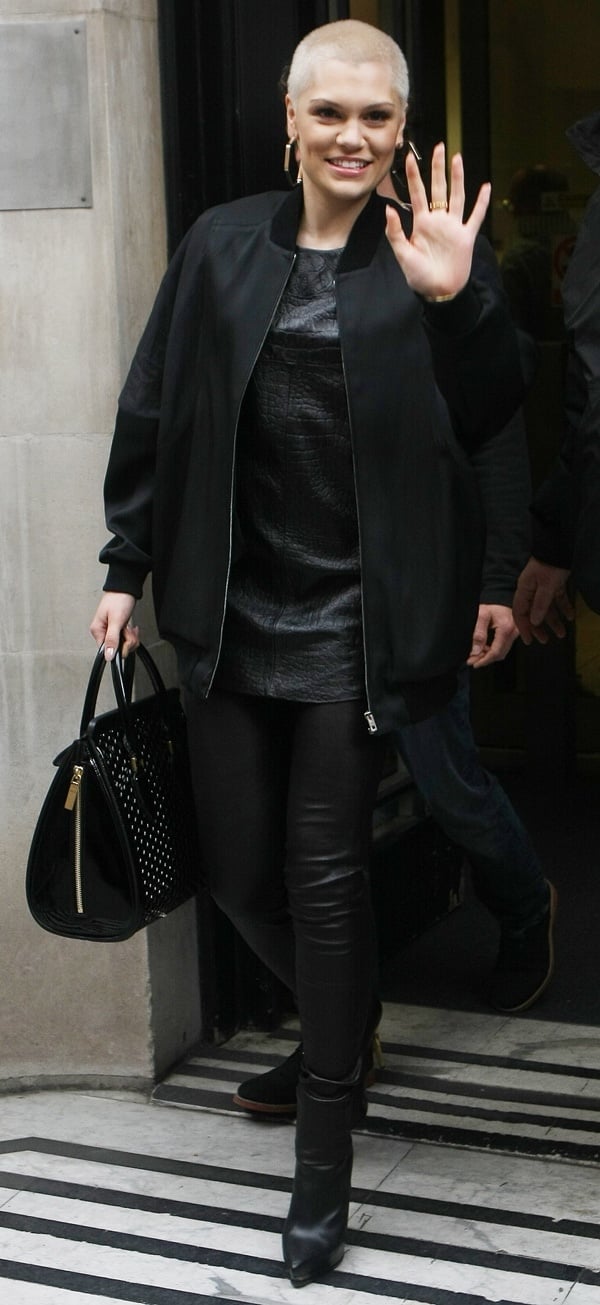 Jessie J rocking tight leather pants, a textured top, and a varsity jacket