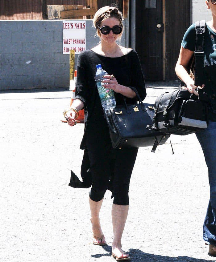 Exiting Third Street Dance Studio, Ashlee Simpson’s attire gleams with an impressive stack of bangles, enhancing her punk-inspired gym outfit