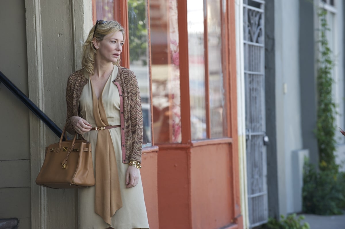 In "Blue Jasmine," Cate Blanchett portrays Jasmine French, a former New York socialite who struggles to cope with the fallout of her husband's financial crimes, leading her to navigate a tumultuous journey of denial, self-discovery, and redemption amidst the ruins of her once lavish lifestyle
