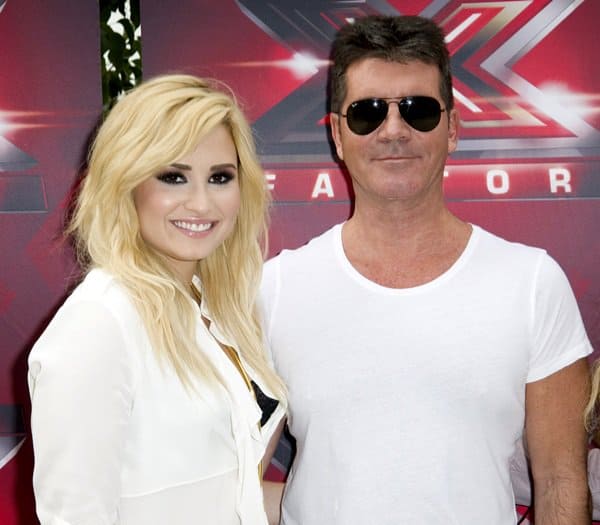 Demi Lovato posing with Simon Cowell