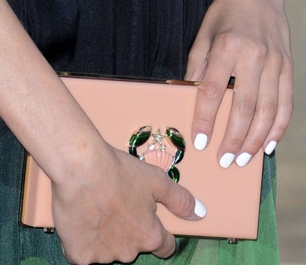 Close-up of Diane Kruger’s Charlotte Olympia Pandora Cancer Zodiac clutch, featuring a blush-pink box silhouette and a jeweled crab emblem that nods to her astrological sign