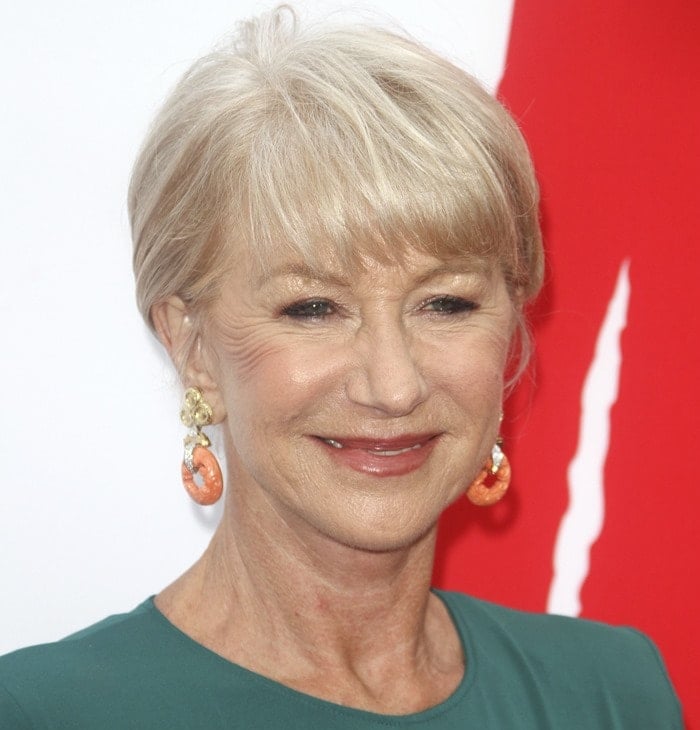 Helen Mirren looks stunning with her chic updo, subtle makeup, and bold coral statement earrings