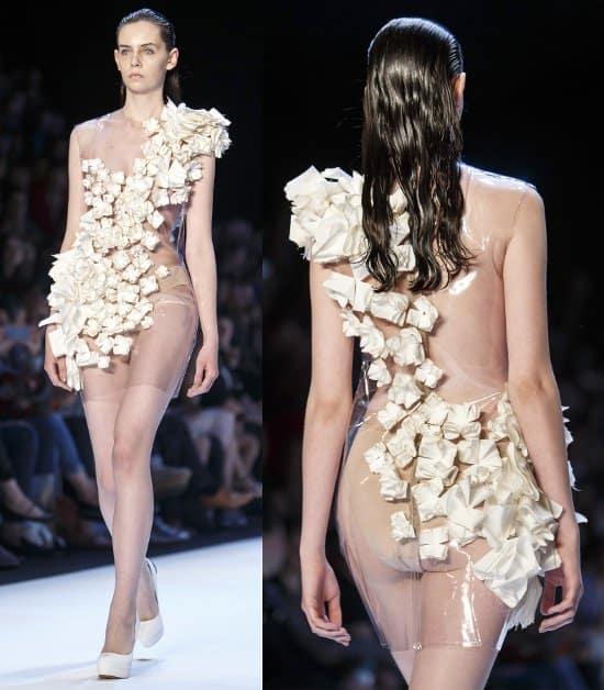 A transparent dress with folded fabric rosettes forming a gorgeous sash