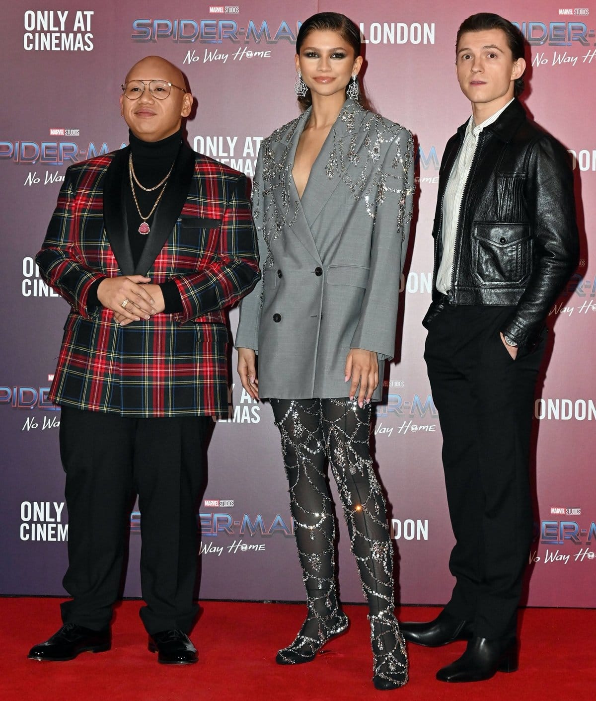 Zendaya towers over Jacob Batalon and her boyfriend Tom Holland at a photocall for Spider-Man: No Way Home