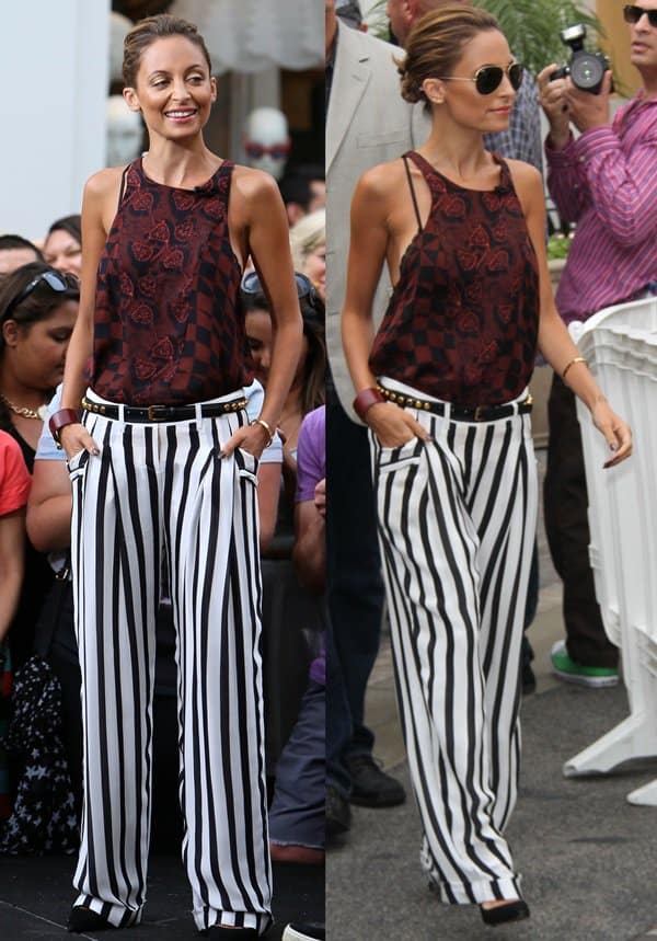 Nicole Richie's outfit on the set of "Extra" in West Hollywood on July 10, 2013, featured a chic combination of Balmain striped silk georgette pants, a blood floral A.L.C. Huntley blouse, a Saint Laurent original skinny studded belt in black and gold, and black Manolo Blahnik BB pumps