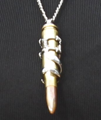 Detail shot of Tyra Banks' striking bullet pendant necklace, adding an edgy touch to her stylish ensemble