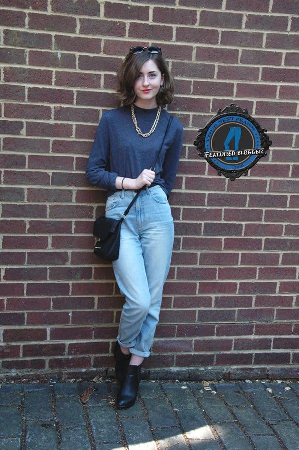 Xenia wears mom jeans with a solid-colored sweater