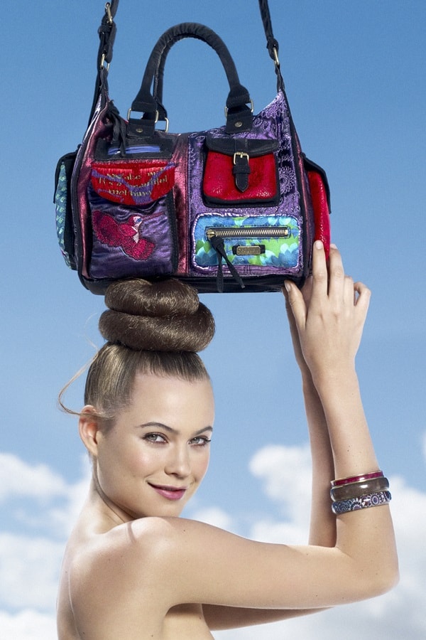 Behati Prinsloo demonstrates a unique talent: balancing Desigual handbags atop her head in a striking campaign pose