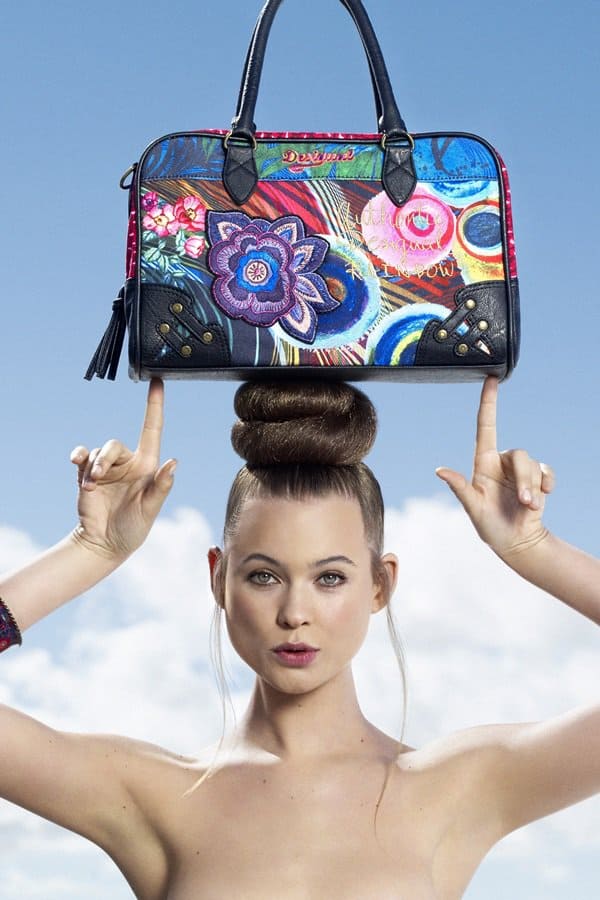 Behati Prinsloo effortlessly balances Desigual's colorful handbags on her head, showcasing her modeling skills in the 2012–2013 Fall/Winter campaign
