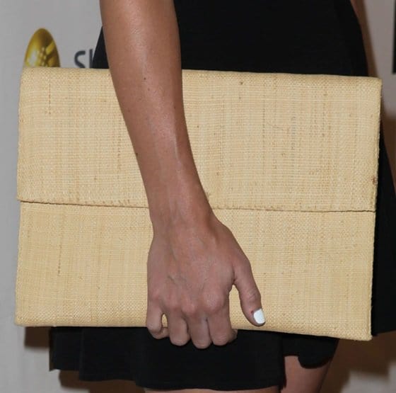 Emily Wickersham’s oversized woven envelope clutch added texture and a modern twist to her black two-piece ensemble