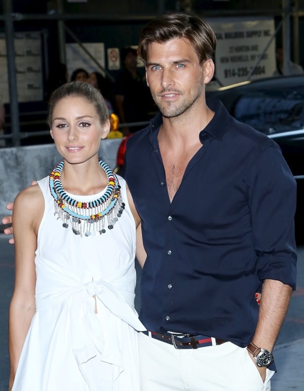 Olivia Palermo radiates elegance in her bold accessories and white dress, standing alongside her dashing boyfriend Johannes Huebl in a classic navy ensemble at the premiere of 'RED 2' in New York City