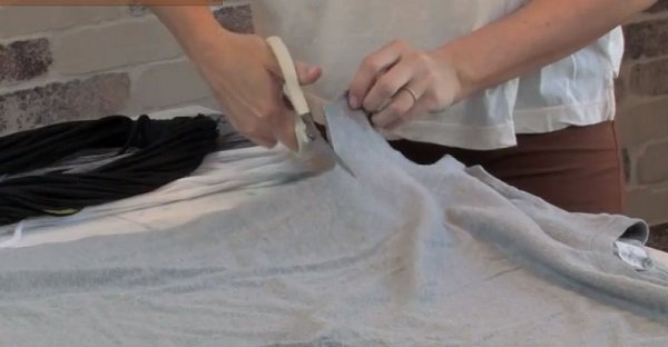 Lay the shirt flat on the table and cut from the armpit down.