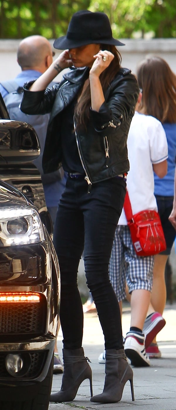 Victoria Beckham pairs a black fedora with a black leather jacket over black separates