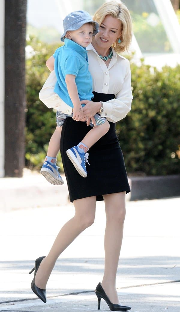 Elizabeth Banks radiates elegance in a white button-down blouse and black pencil skirt, complemented by classic black pumps, on the set of 'Love and Mercy'